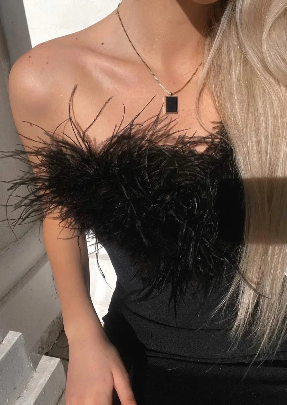 Vestido largo negro sin tirantes con detalle de plumas