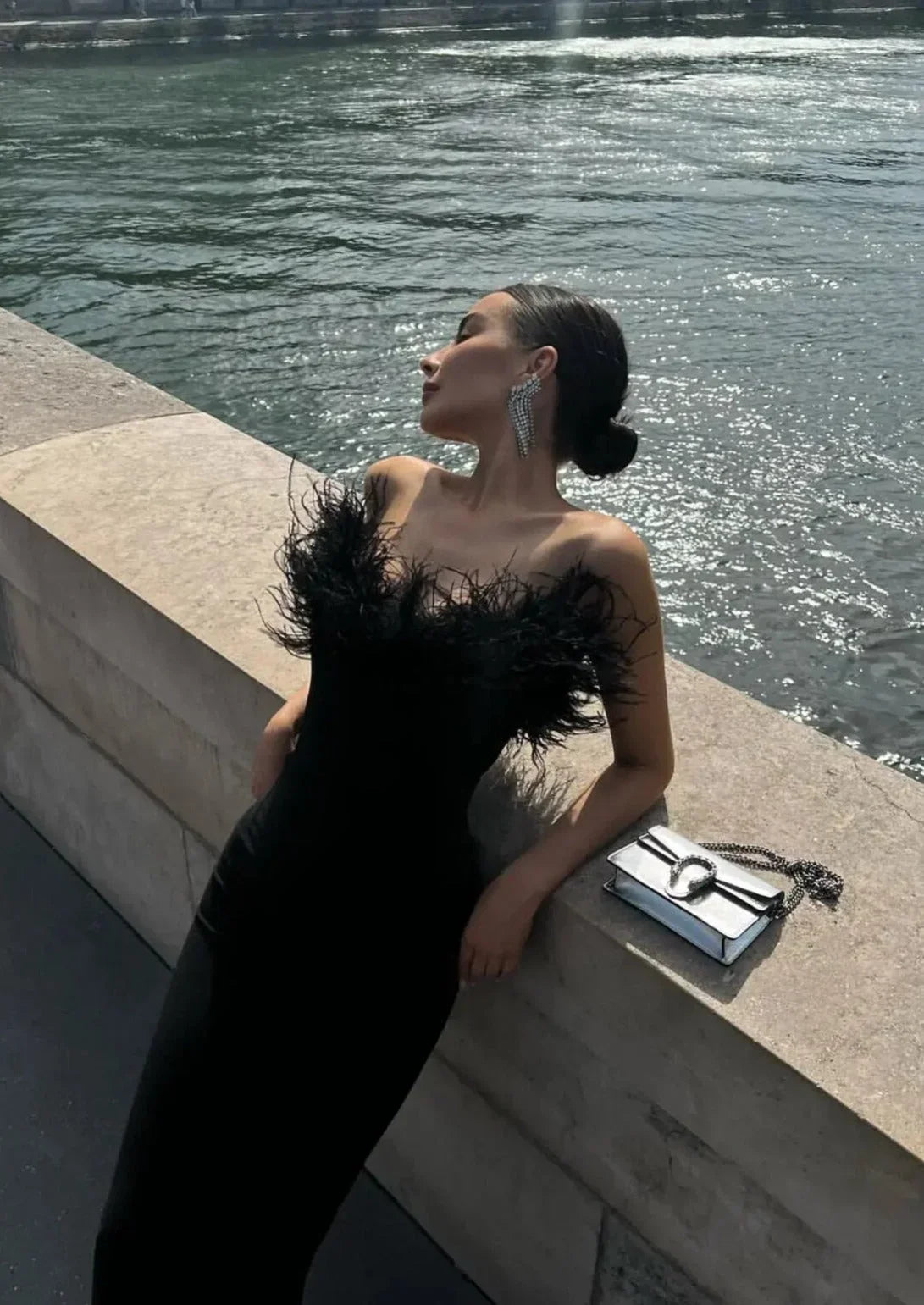 Vestido largo negro sin tirantes con detalle de plumas